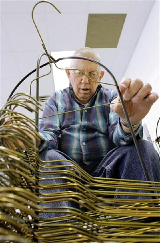 Ed Harp straightens hangers at SPARC, an agency that helps people with developmental disabilities, in Springfield, Ill. The state owes SPARC about $2.5 million.